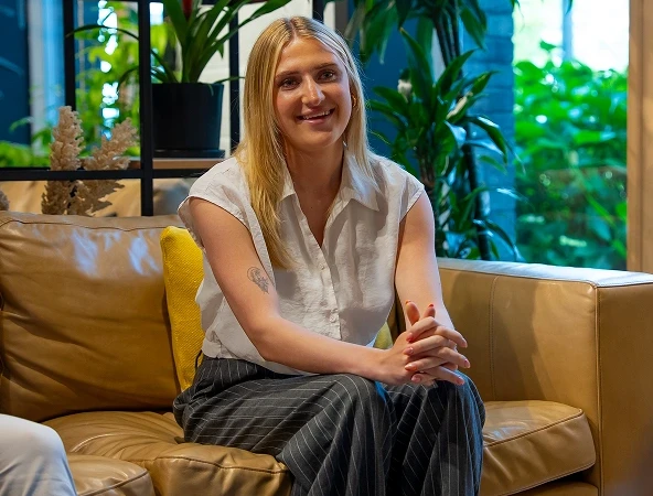 Woman smiling on a couch, part of the team at insolvency practitioners Stoke-on-Trent office.