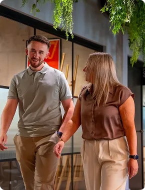 Two insolvency practitioners walking and talking together in a modern office hallway.