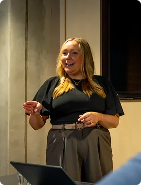 Nicky presenting a business finance talk at a podium with a laptop in front of her.